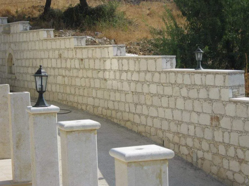 Stone balustrade with capped posts along a garden wall