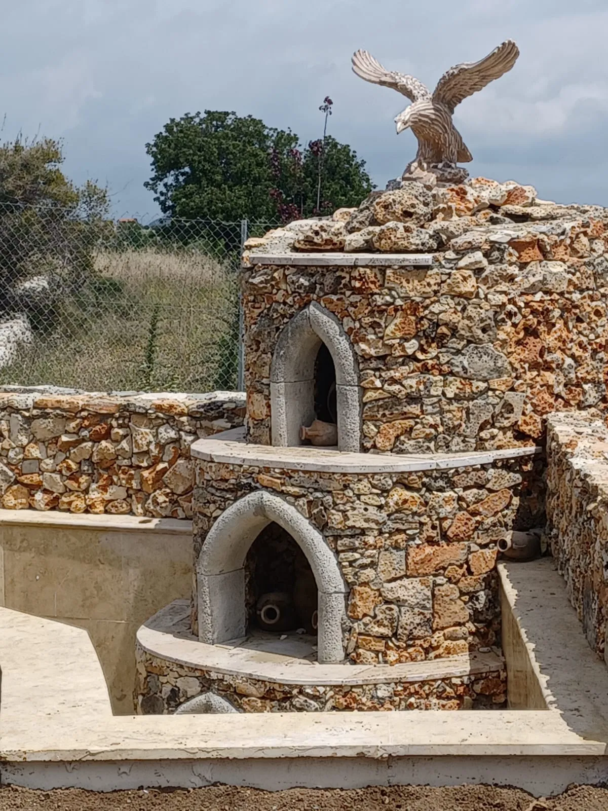 Built-in rough stone barbecue topped with a carved eagle
