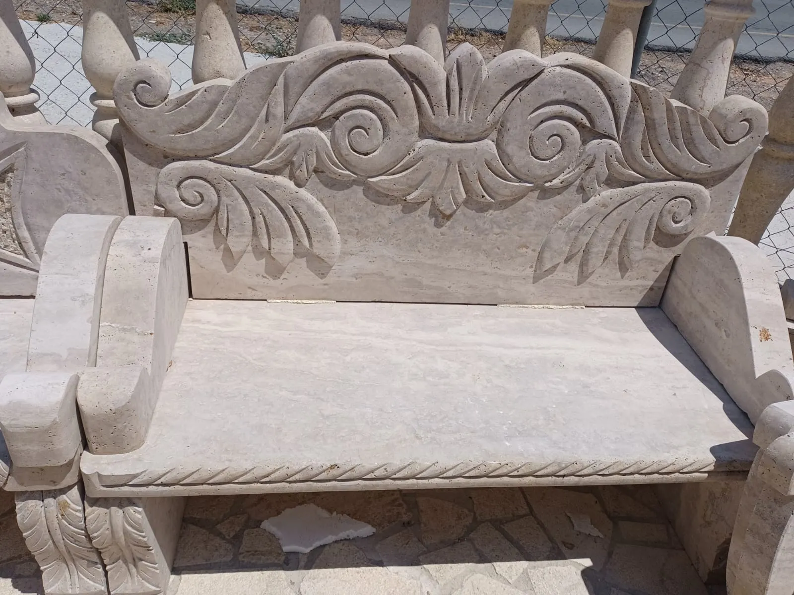 Stone garden bench with a carved floral backrest