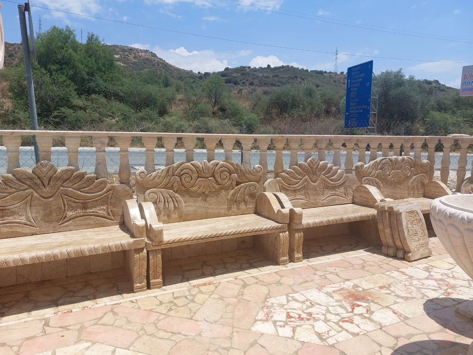 Pair of carved stone benches beside a balustrade on a paved terrace