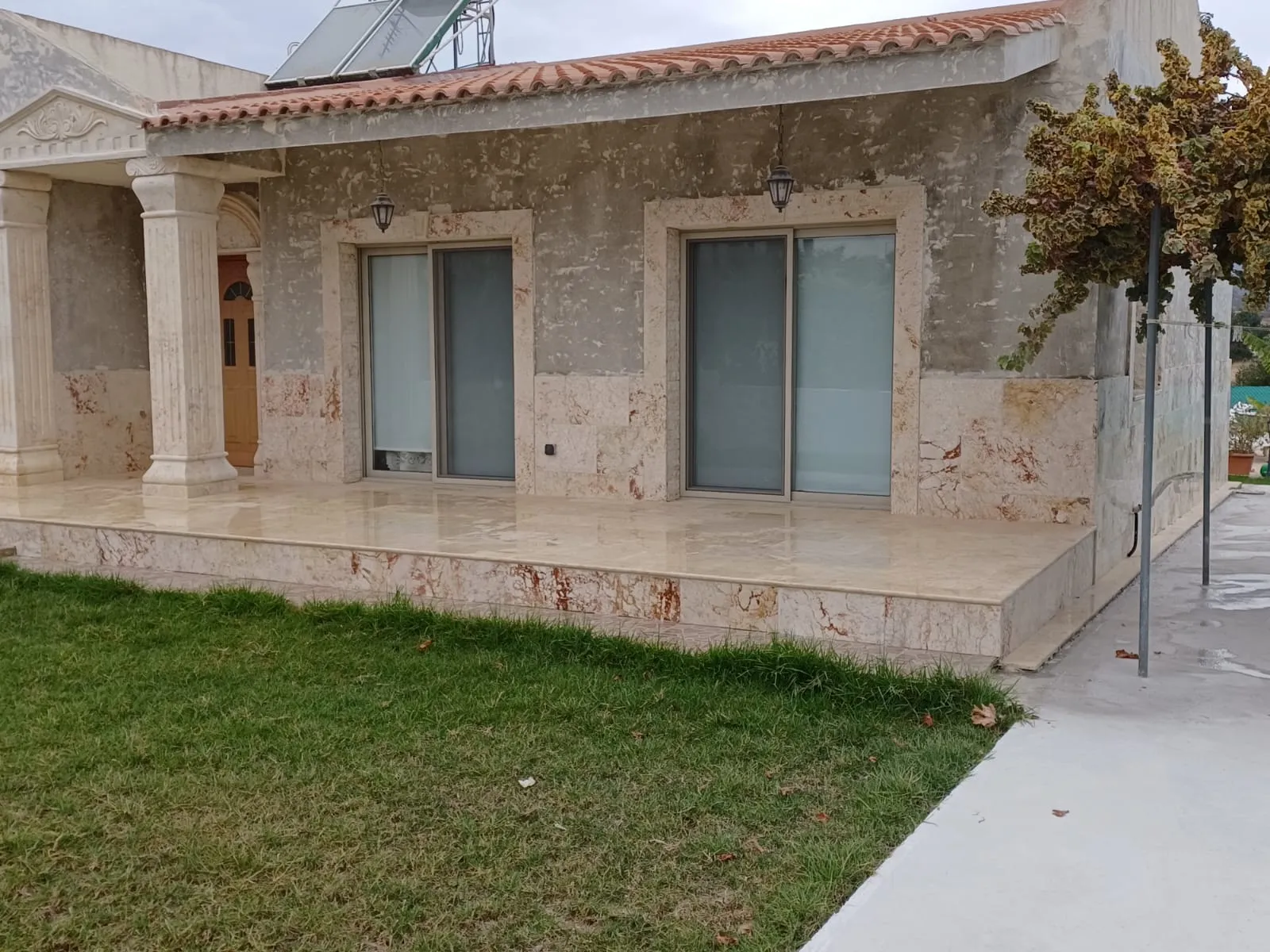 House with full natural stone cladding and a stone terrace