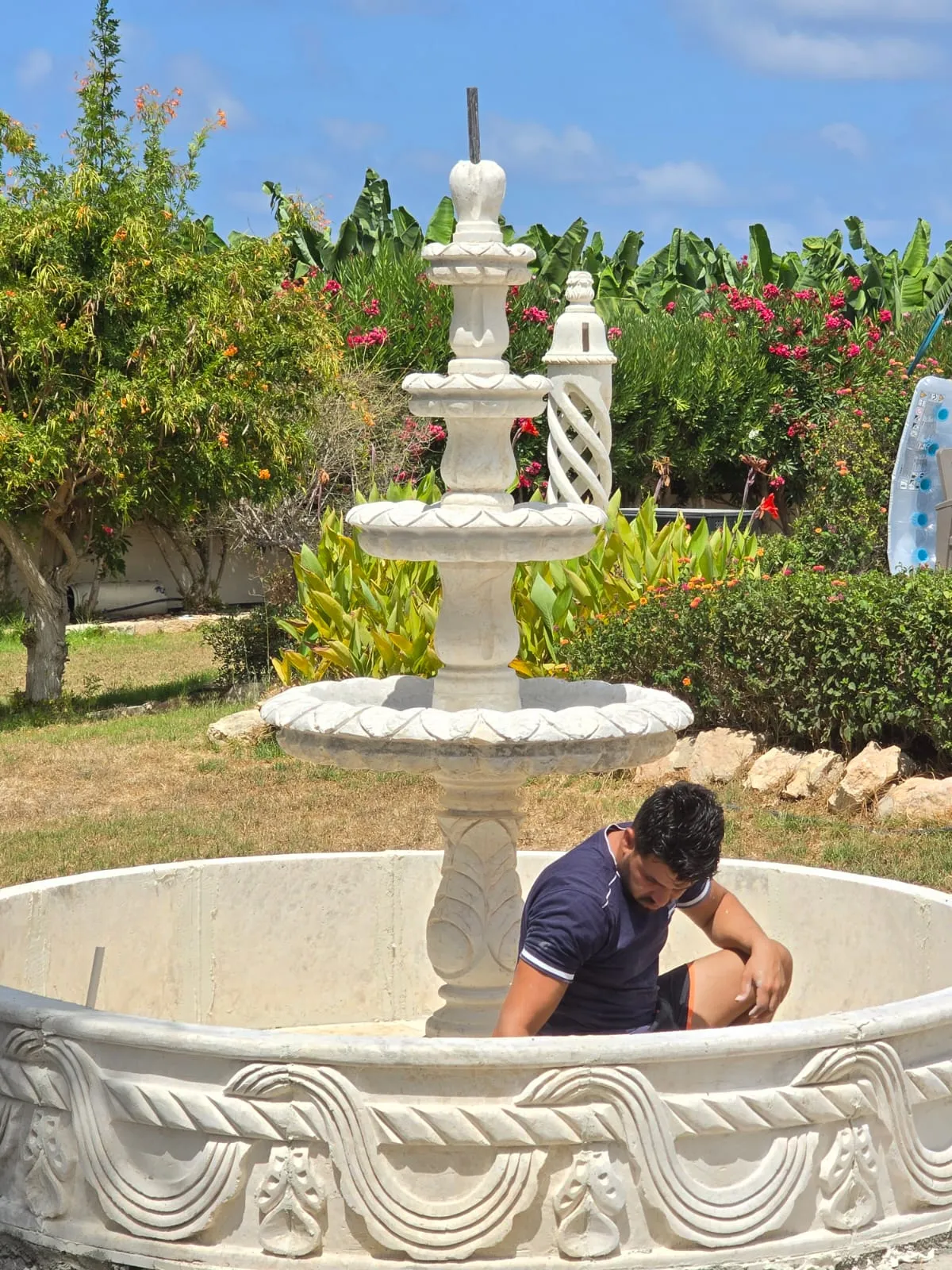 Tiered stone fountain with a wide carved basin in a garden