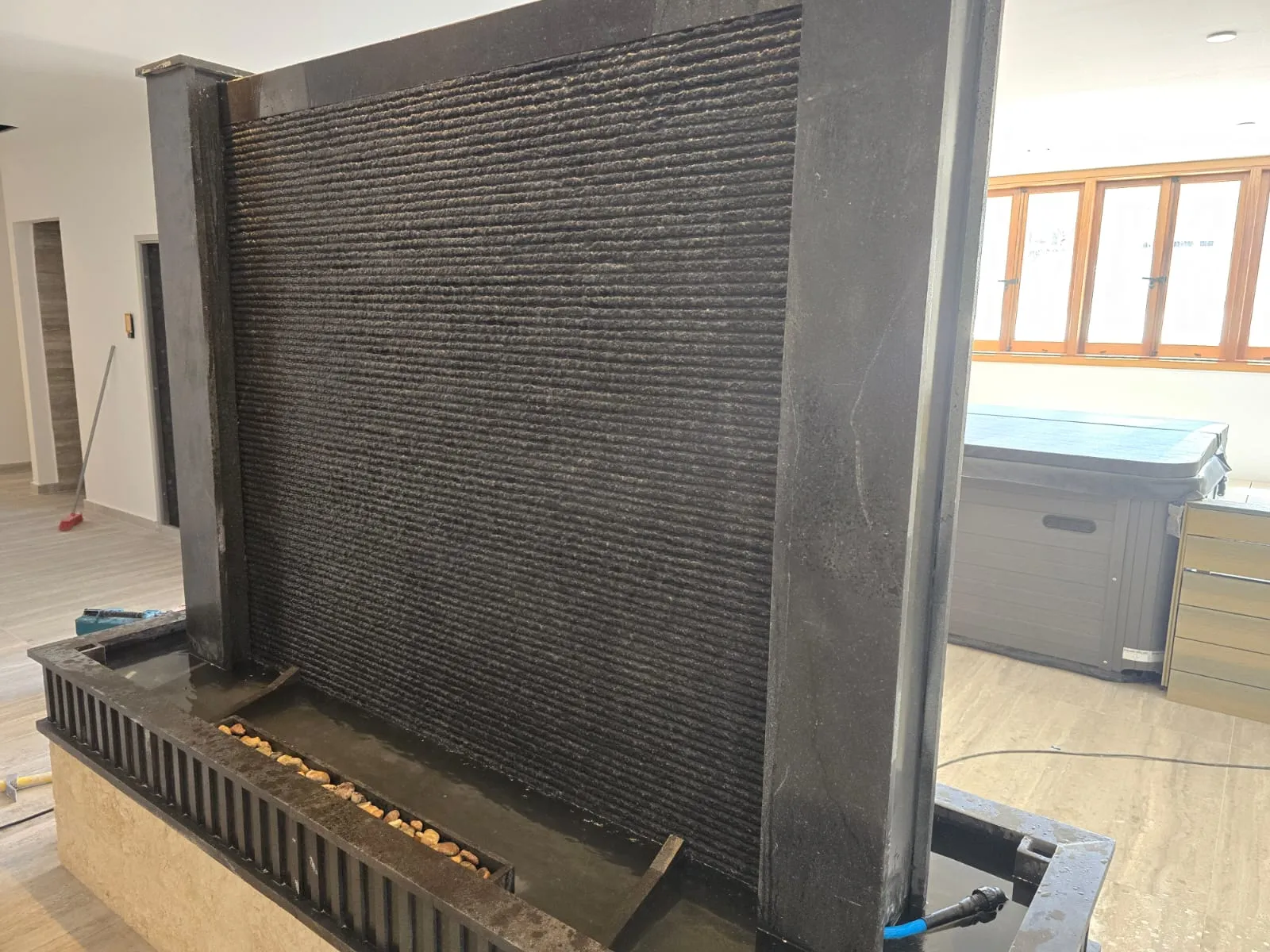 Slate water wall feature beside an indoor pool