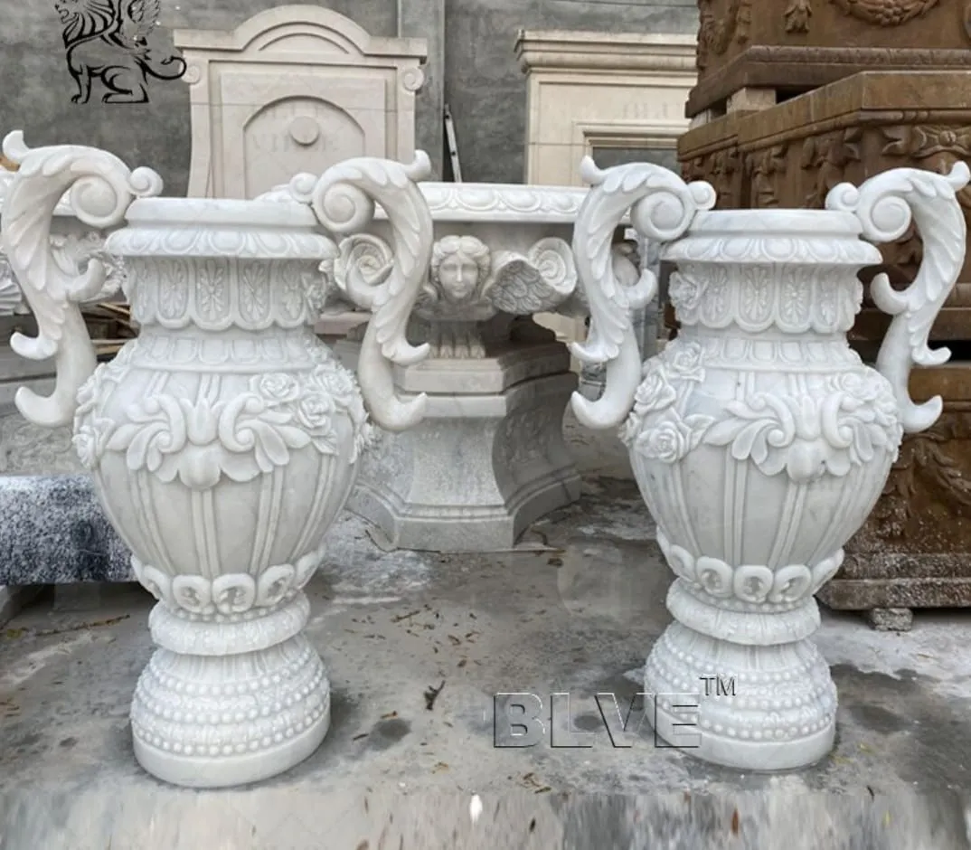 Pair of classical carved stone urns with handles