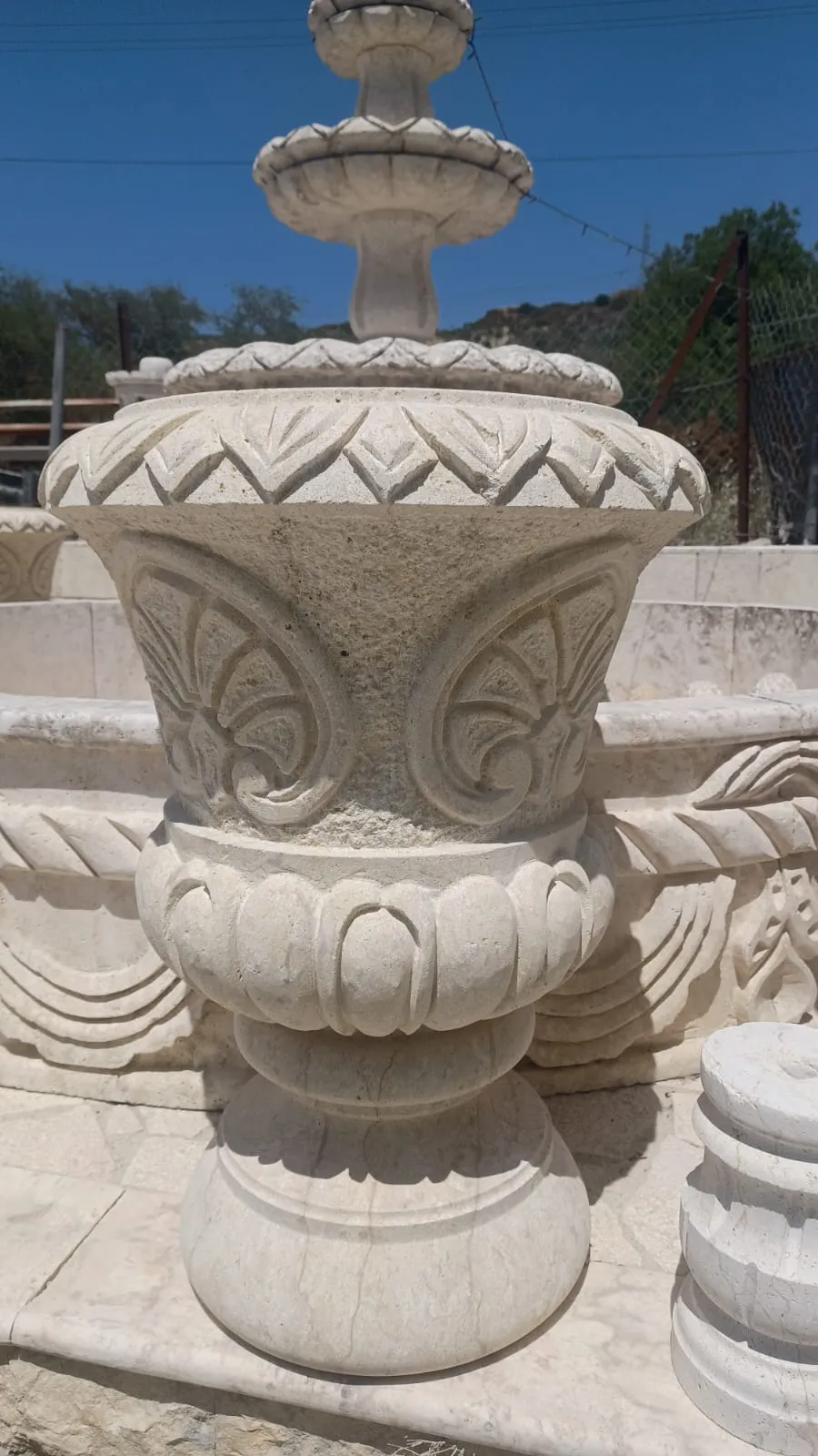 Carved stone urn planter in the workshop yard