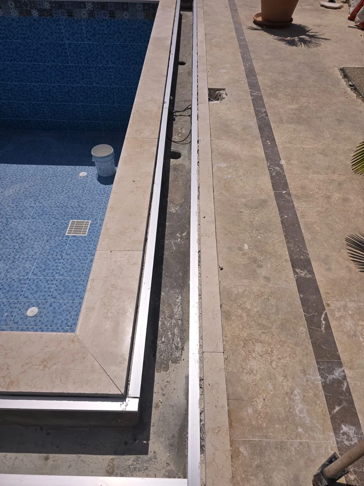 Bullnosed stone coping along a swimming pool edge