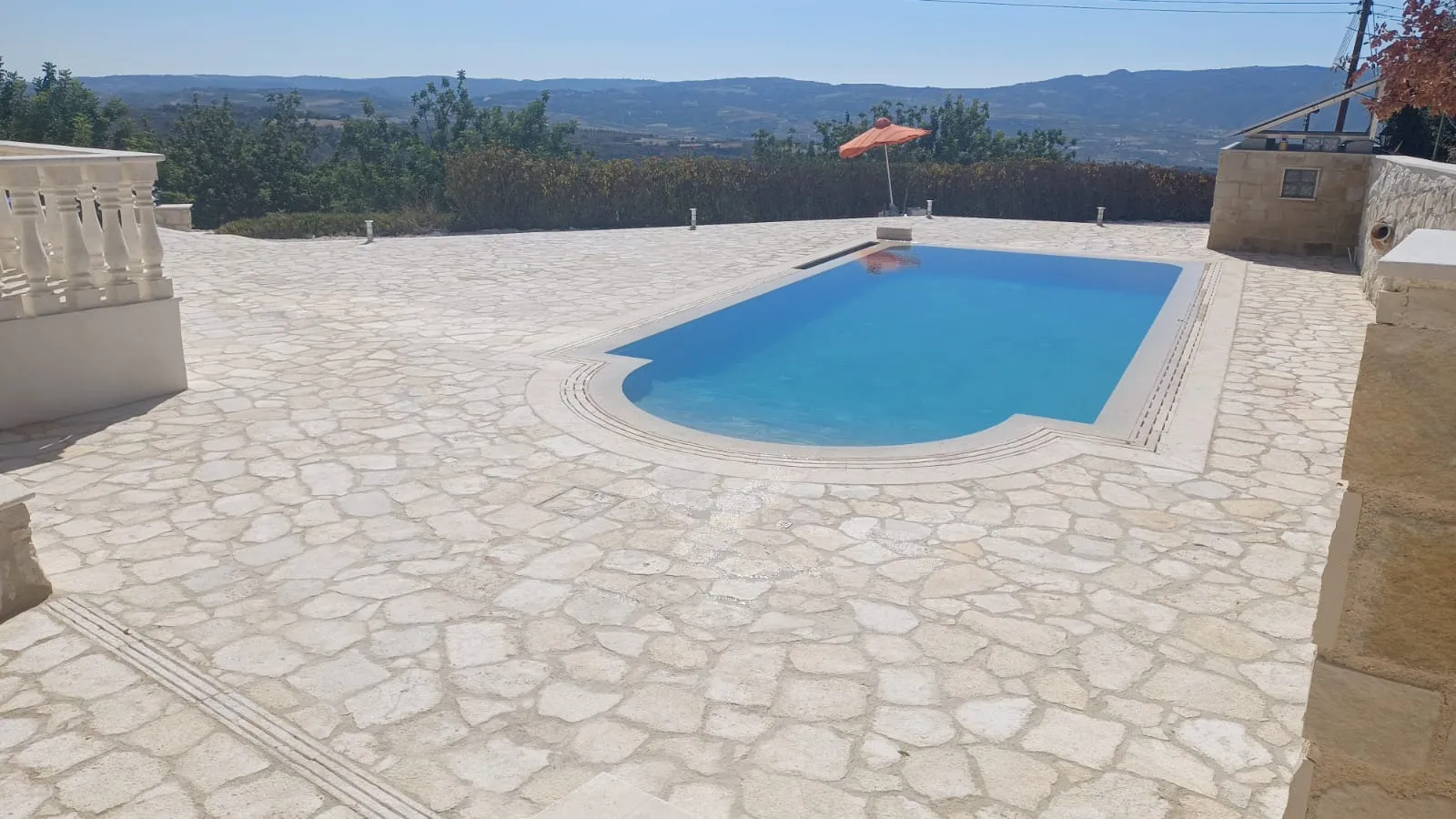 Crazy-paved natural stone terrace around a private pool