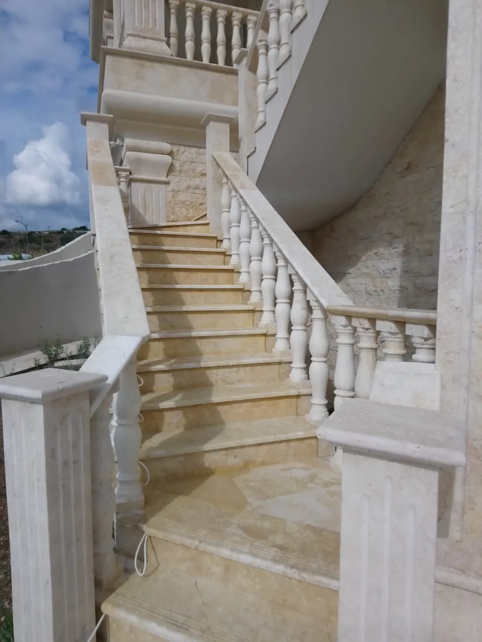 Marble staircase with a turned stone balustrade and matching landings