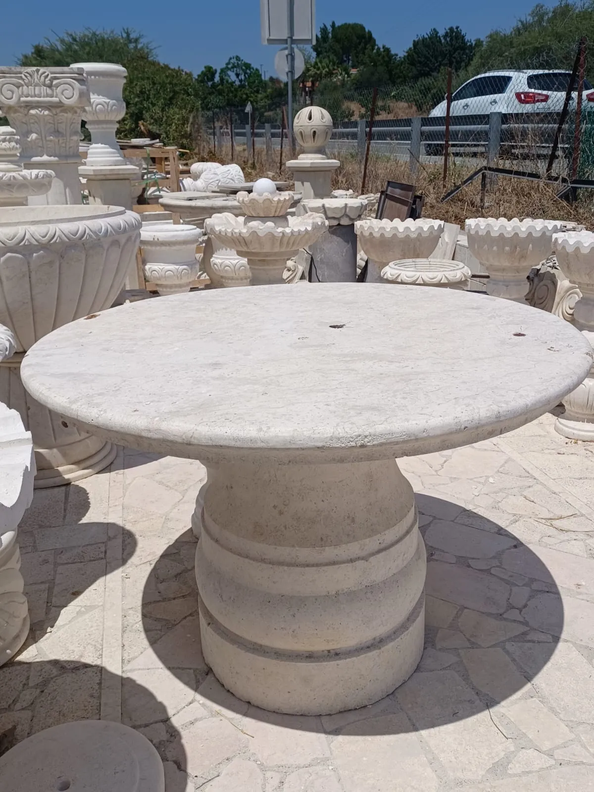 Round stone table on a carved pedestal base